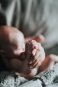 يد بالغ تمسك بيد طفل رضيع صغيرة كرمز للترابط والرعاية