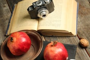تفاحة حمراء طازجة إلى جانب كتاب يرمز لفوائد التفاح اليومية