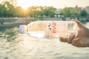 شخص يحمل زجاجة مياه شفافة كرمز لأهمية شرب الماء الكافي يوميًا لتعزيز المناعة