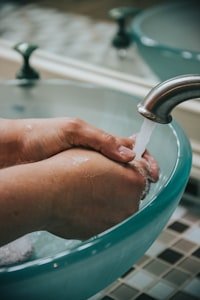شخص يغسل يديه تحت الماء كعادة يومية أساسية لتعزيز المناعة والوقاية من العدوى