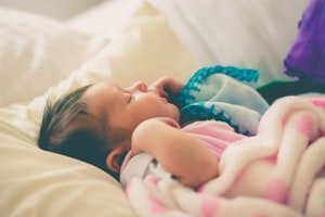 طفل رضيع نائم بهدوء في سريره